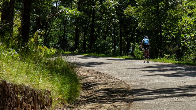 A man biking up the steep road to Hot Springs Mountain 