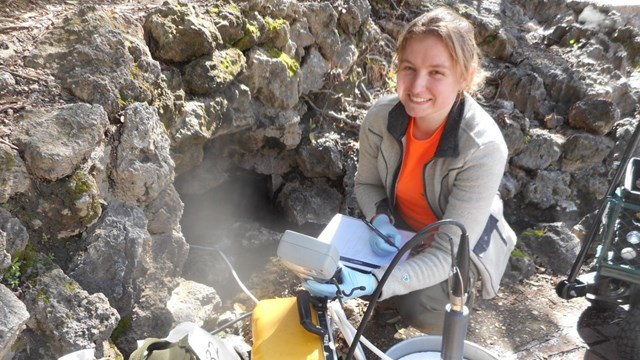 Female scientist is testing the thermal springs water, surrounded by her equipment.