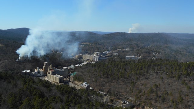 Smoke rises through the forests behind downtown Hot Springs.