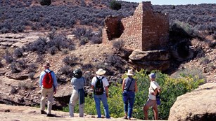 A group of people looking at a rock structure