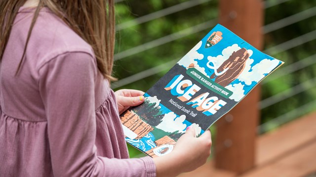 Photograph of child holding Ice Age National Scenic Trail Junior Ranger Activity Booklet
