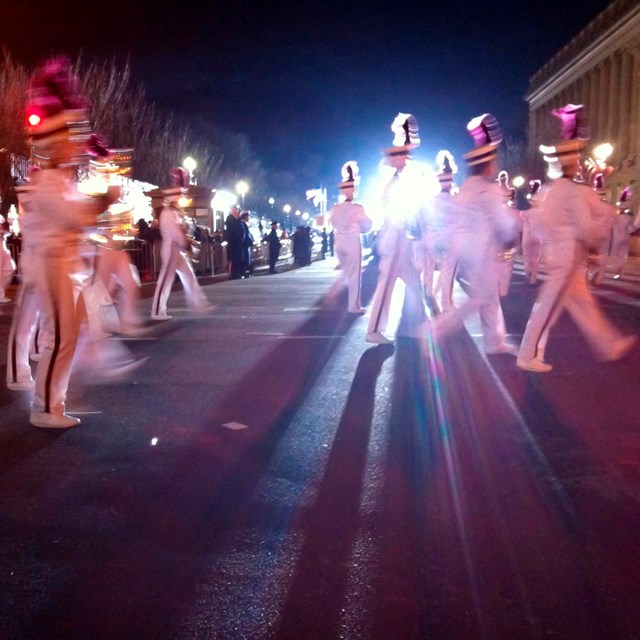 Marching band walking in a parade at night