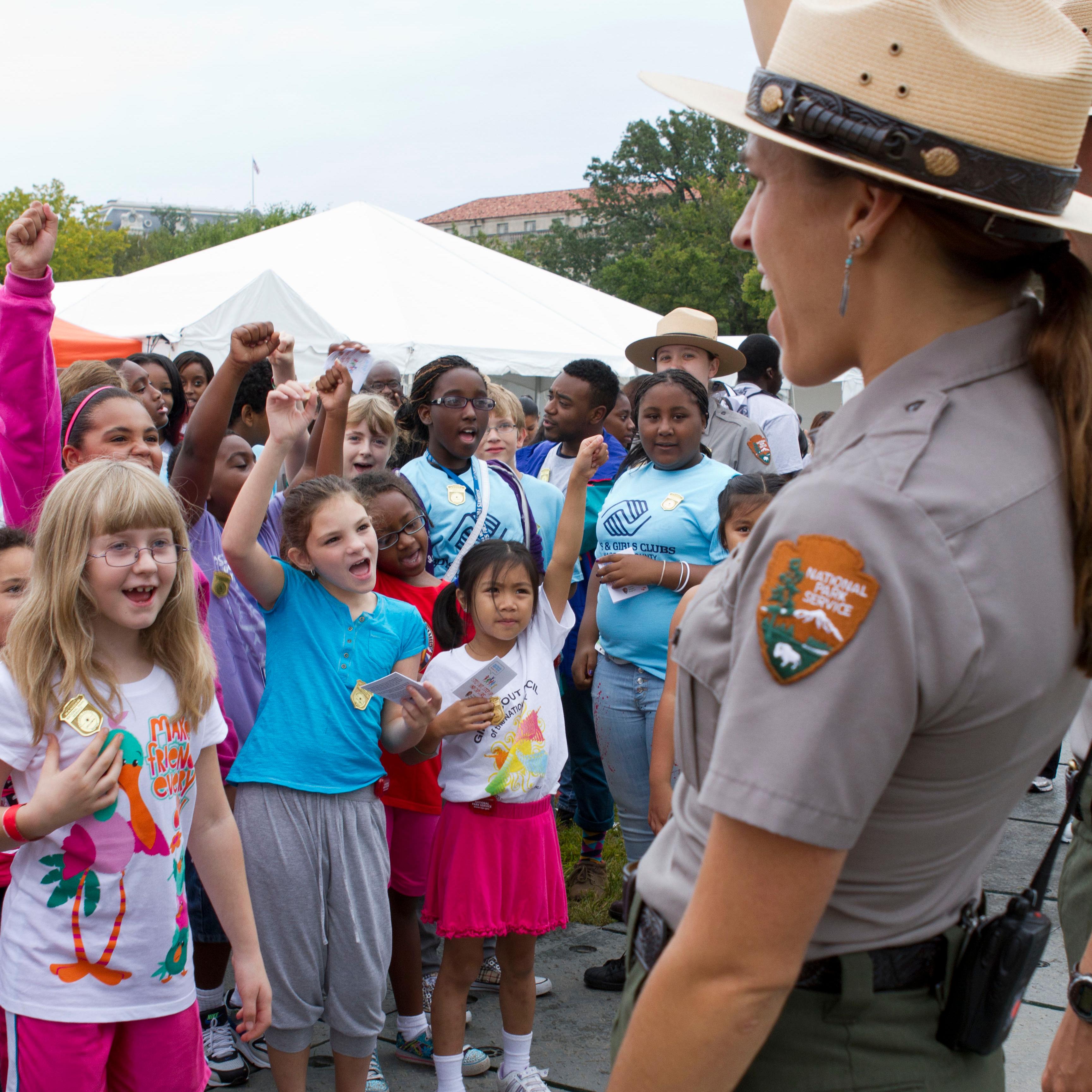 Group of kids wearing Junior Ranger badges holding hand up to take the Junior Ranger pledge