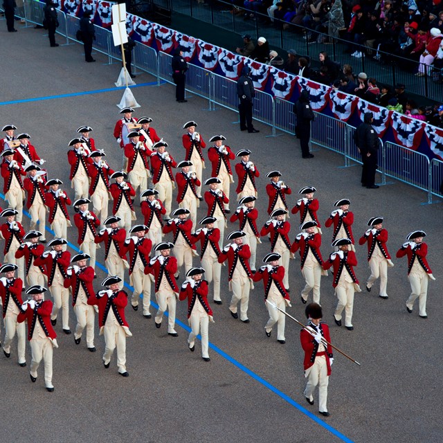 Military fife and drum core wearing traditional 18th-century uniforms