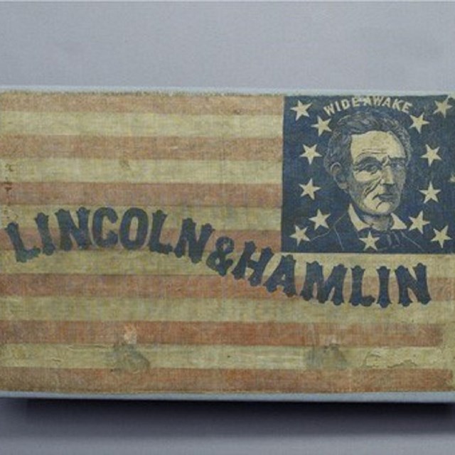 Historic campaign flag with an image of Abraham Lincoln and text reading 