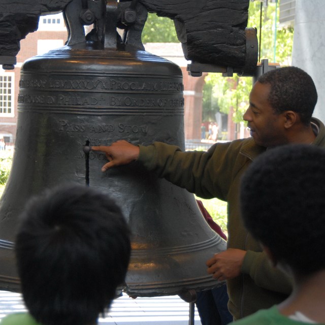 Park ranger pointing to the crack on the Liberty Bell