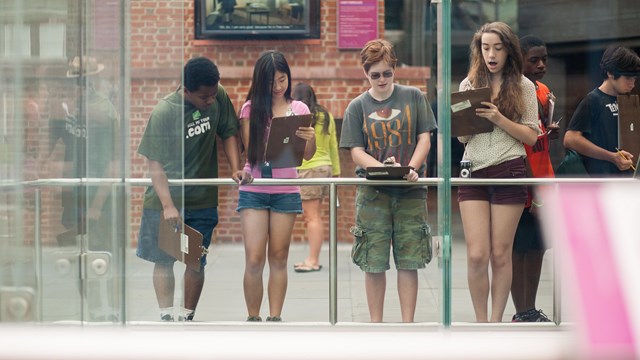 Color photo of four teens looking at an exhibit at the President's House Site.