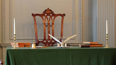 Assembly Room, showing chairs and tables covered with green tablecloths.