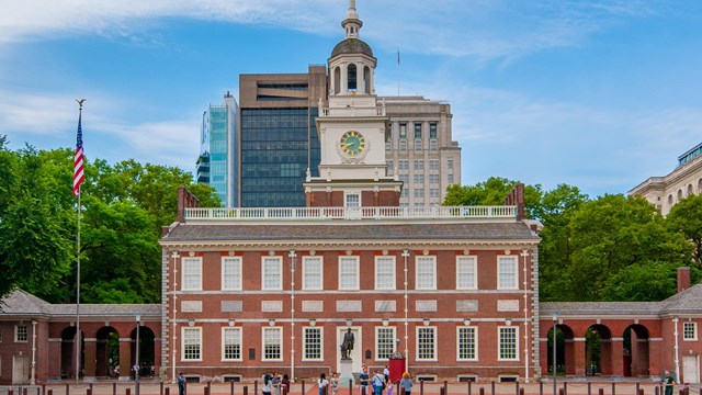 Color photo of Independence Hall, a two story red brick building with bell tower.