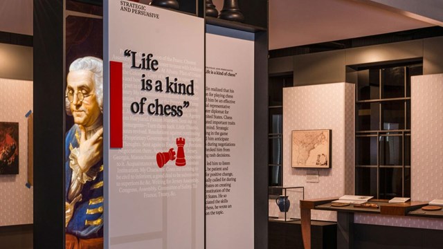 Benjamin Franklin Museum exhibit panel in the foreground with the museum in the background.