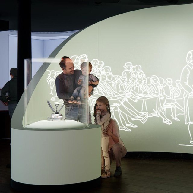 Two people examining historic documents in artifact display cases.
