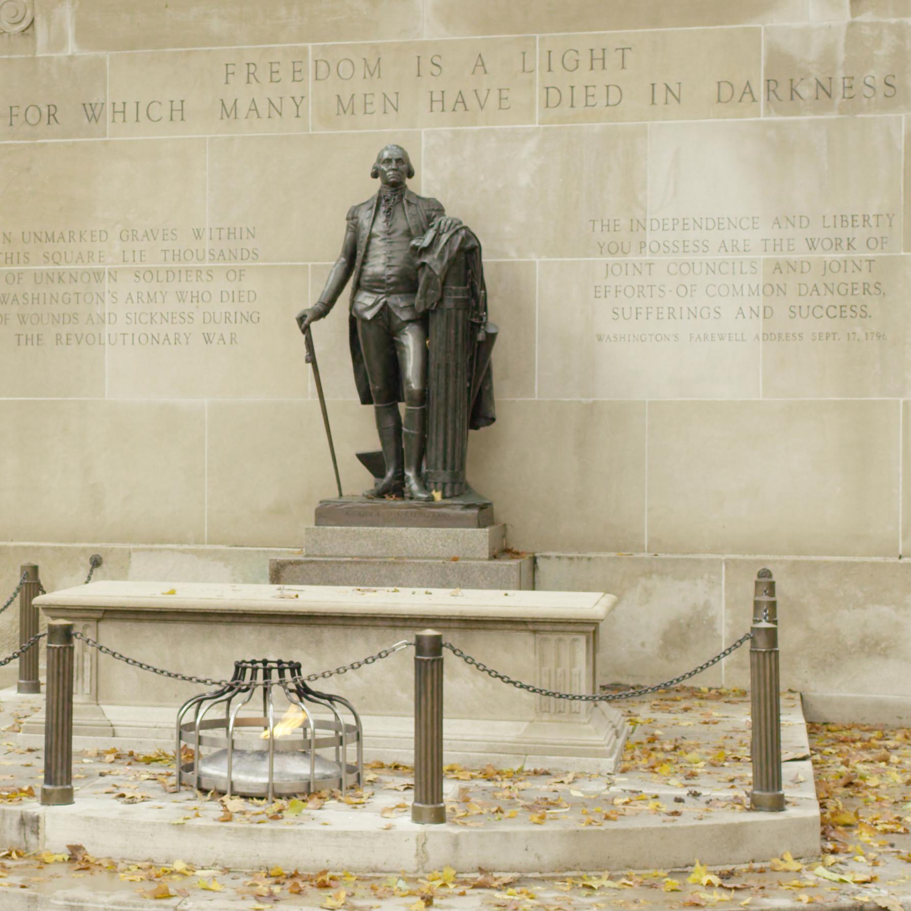 Bronze statue of George Washington overlooking a tomb