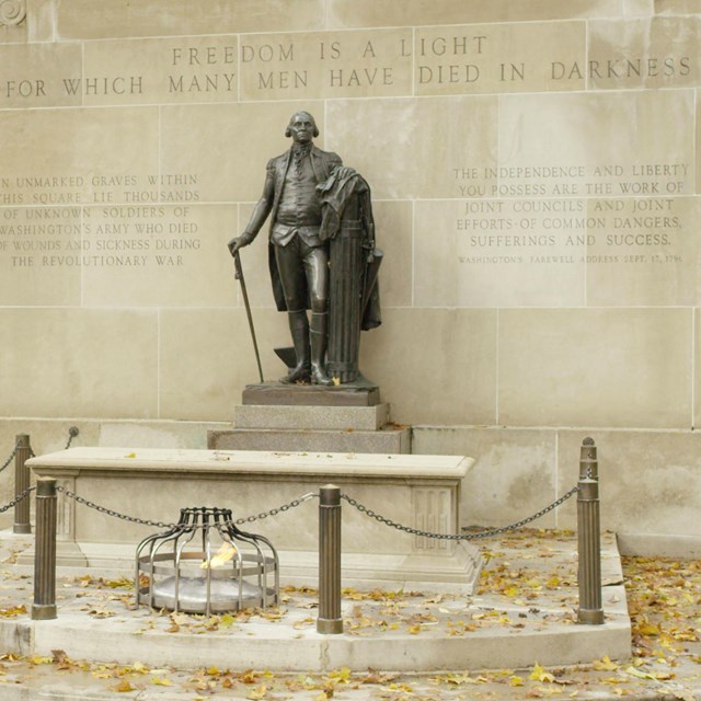 Bronze statue of George Washington overlooking a tomb