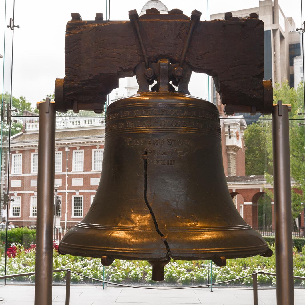 Color photo of the Liberty Bell suspended by two steel supports.