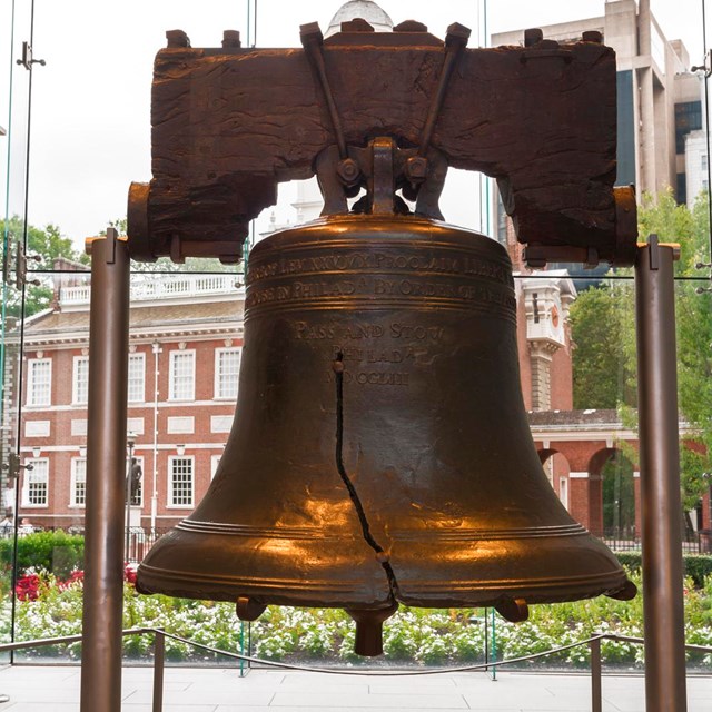 Color photo of the Liberty Bell suspended by two steel supports.