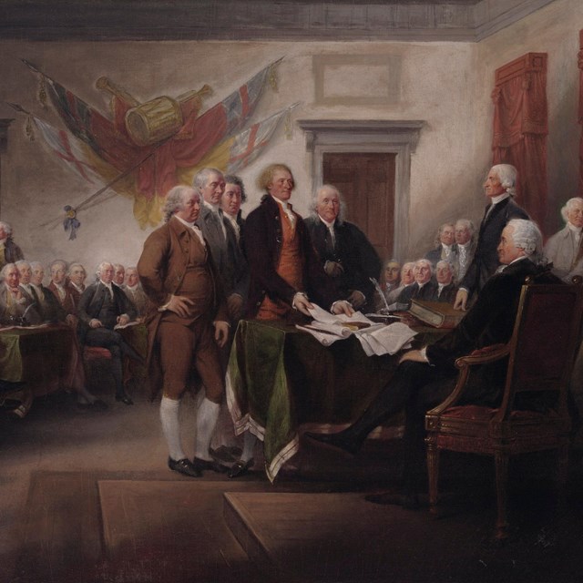 Color painting showing a committee of five men presenting the Declaration to a seated man.