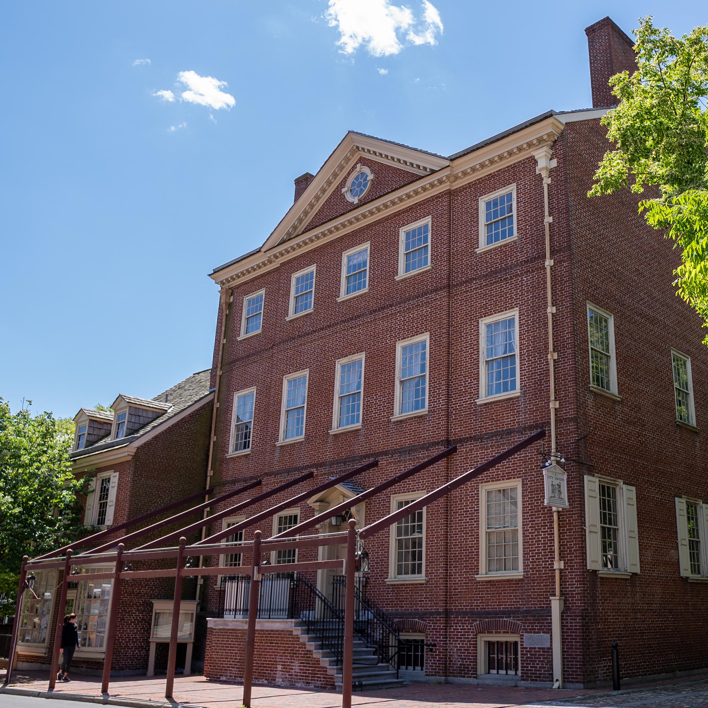 Exterior view of three story red brick building with numerous windows on each level.
