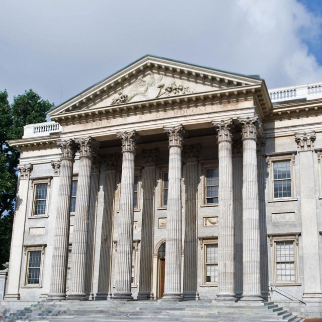 Color photo of marble building with columns supporting a triangular pediment.