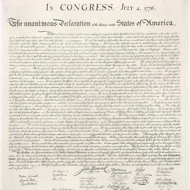 Color photo of a woman and child each holding the Declaration of Independence.
