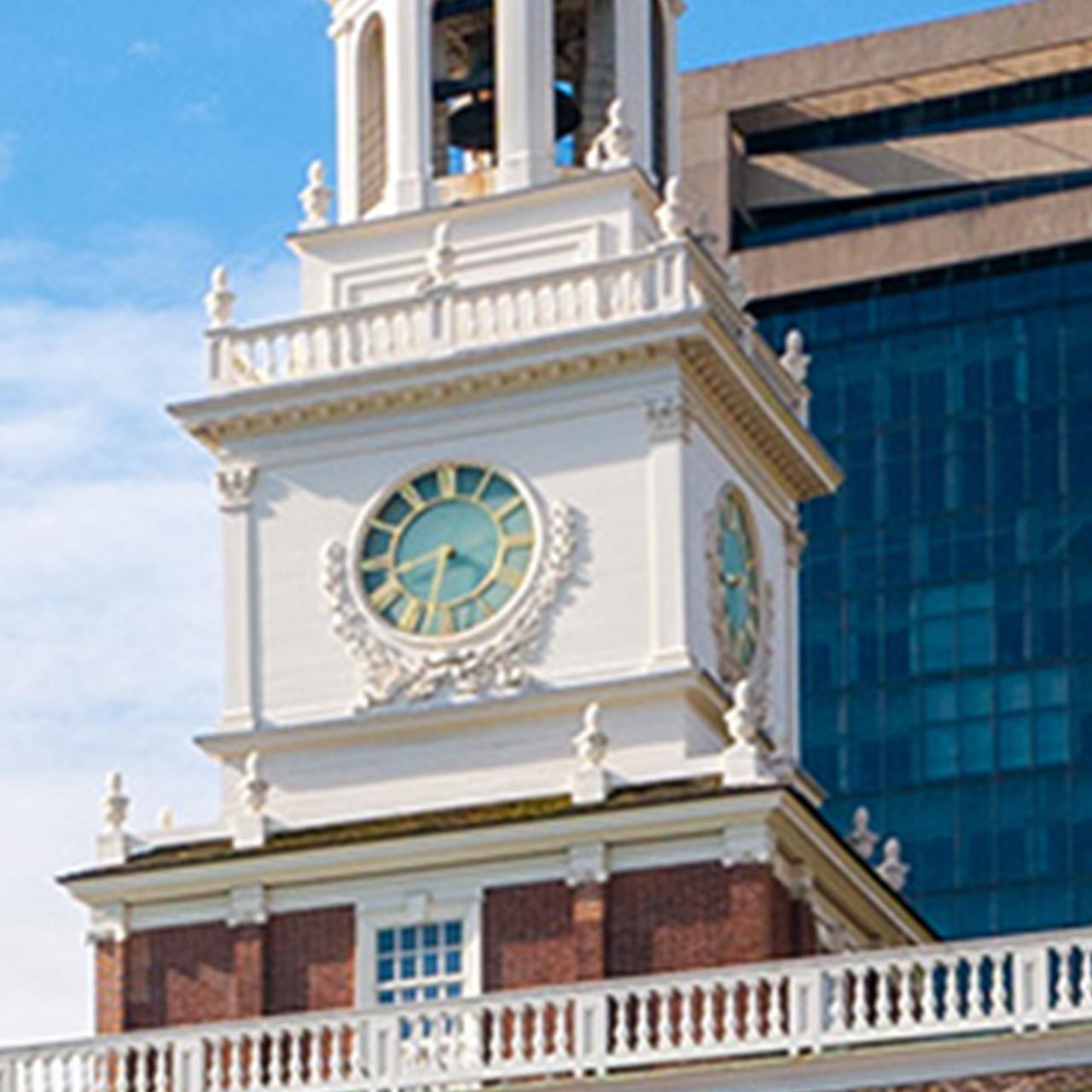Color photo of a clock face on a white tower of Independence Hall