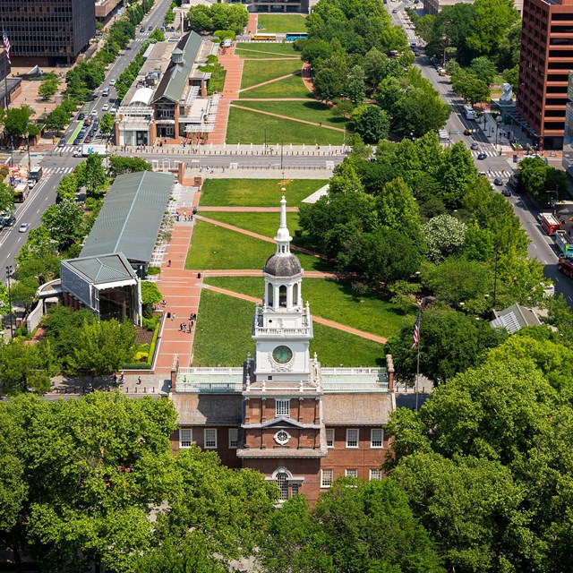 Aerial view of brick building with white clock tower and expansive view of the city of Philadelphia.
