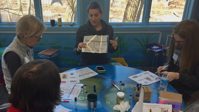Female scientist explains a water quality concept to educators