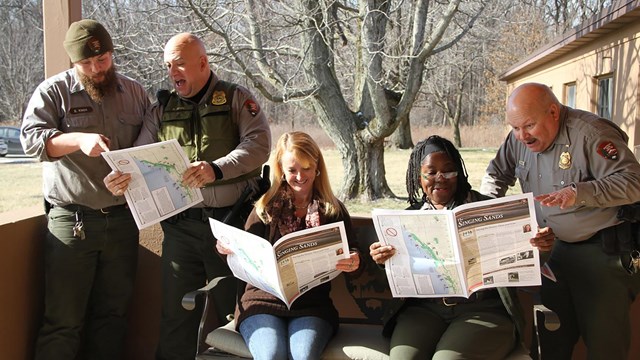Group of park employees reading Singing Sands newspaper.
