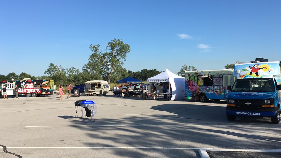 A line of food trucks form in a parking lot at West Beach.