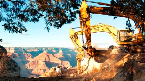 Excavator by the rim of a rim canyon