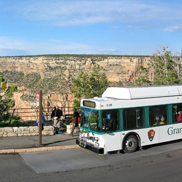 Shuttle bus pulling up to a stop on a canyon rim