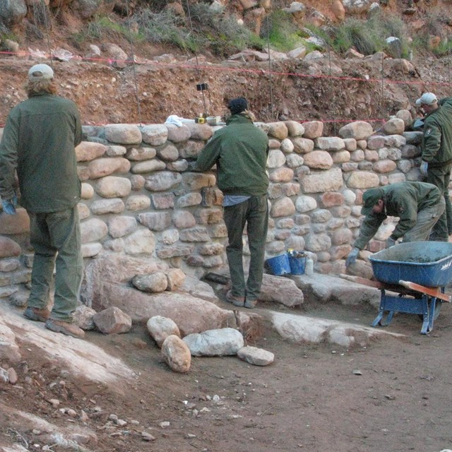 Trail crew working on a vertical stone wall