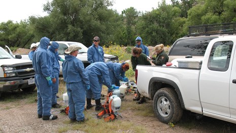 group of workers examine equipment next to a pick up truck