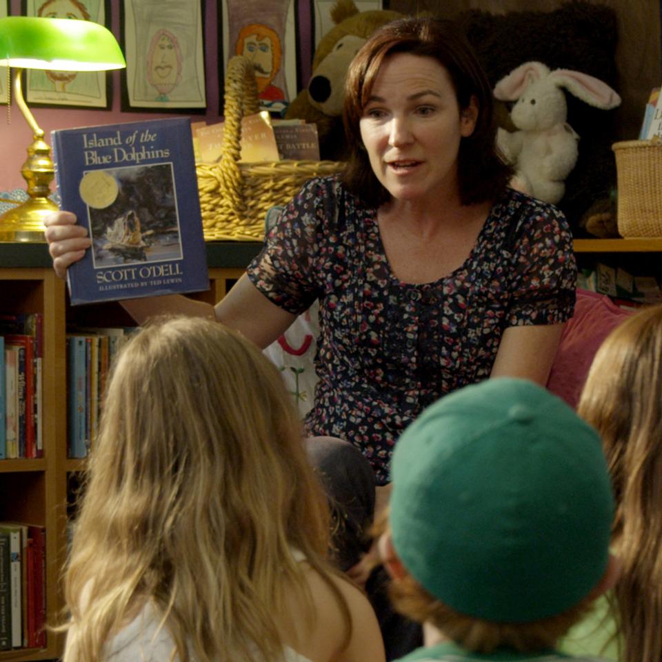 Teacher sharing book with students.