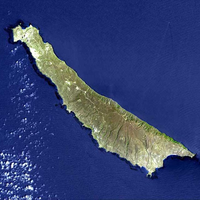 Aerial view of long skinny island with blue water. 