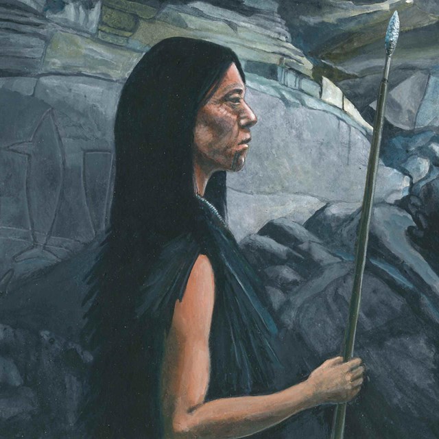 Native American Indian woman standing in cave looking outside.