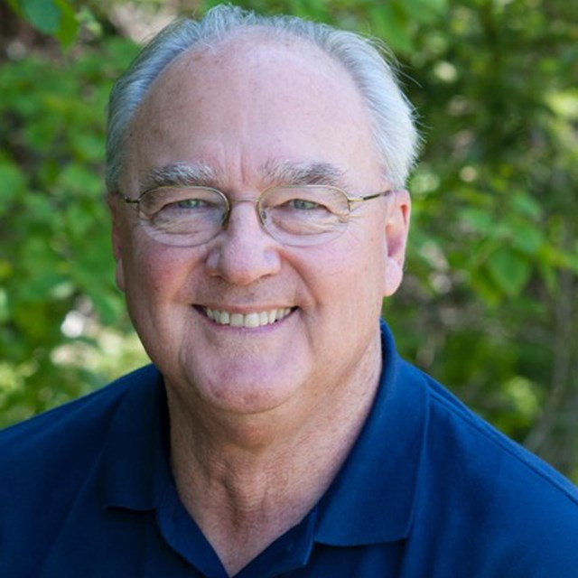 Man with glasses and blue shirt.