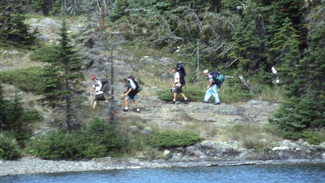 A group of campers backpacks along Rock Harbor Channel.
