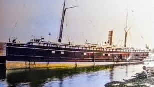 steamship docked with person looking on from a distance