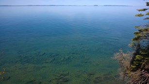 Vast expanse of calm, blue water stretches from the shoreline of the island to Canada.