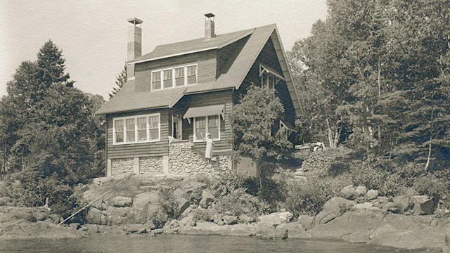 ornate two story house overlooking the Rock Harbor channel, two chimneys and 10 windows visible