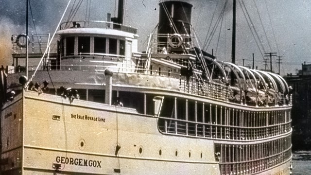 closeup bow view of the SS George M. Cox with a harbor evident in the background