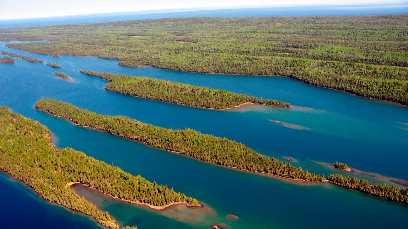An aerial view of a chain of forested islands on Lake Superior.