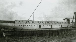 steamship being constructed, held upright by a wood frame