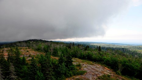 A dark gray storm cloud rolls over the Greenstone Ridge.