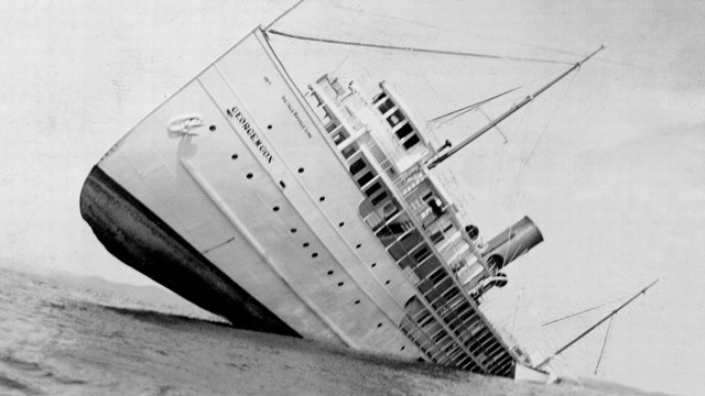 steamship tilting badly, stuck on reef and sinking