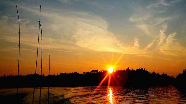 A sunset scene with fishing poles