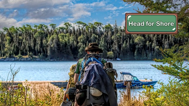 A hiker with a large backpack approaching a shoreline.