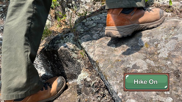 A close up of brown boots hiking on rocks.