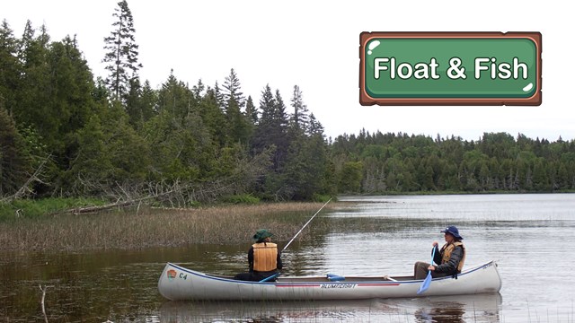 A person fishes from the front of a canoe while their partner paddles.