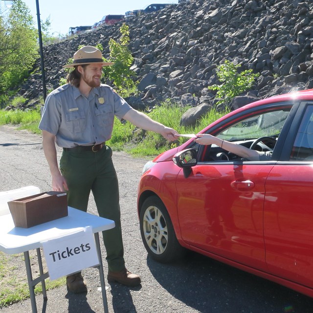 A ranger in uniform hands tickets for the Ranger III in Houghton Michigan.